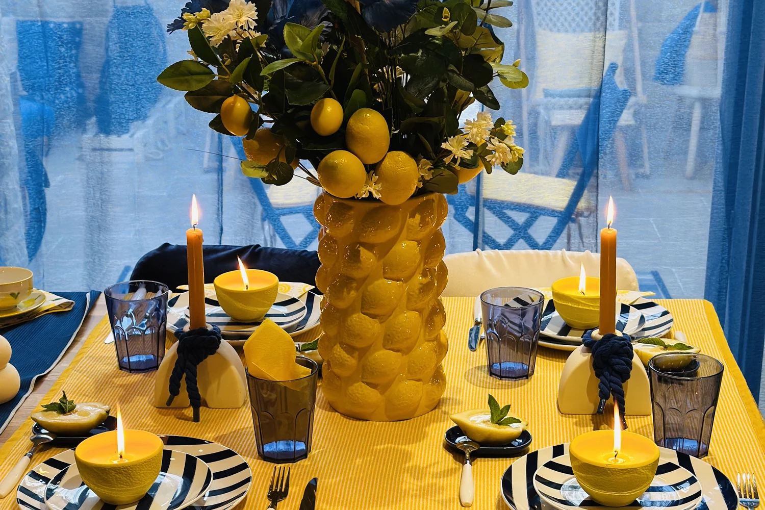 Hélios & Mykonos — table bleu et jaune, vase citrons, faïence rayée et bougies, scénographie EVEN'IN